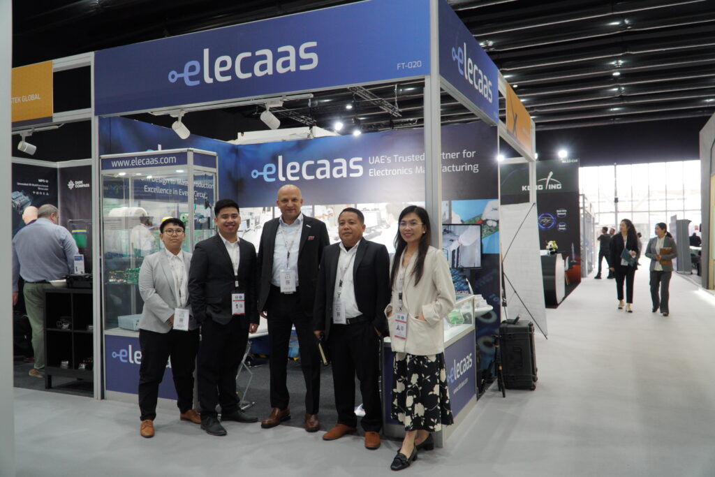 Elecaas exhibition booth FT-020 at IDEX 2025, showcasing the Elecaas team including Chairman/CEO Basel Abudaqa